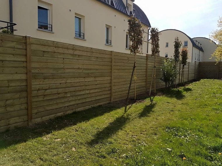 Clôture en bois le long d'une pelouse