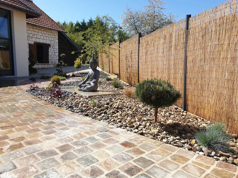 Jardin zen avec statue et allée en pavés