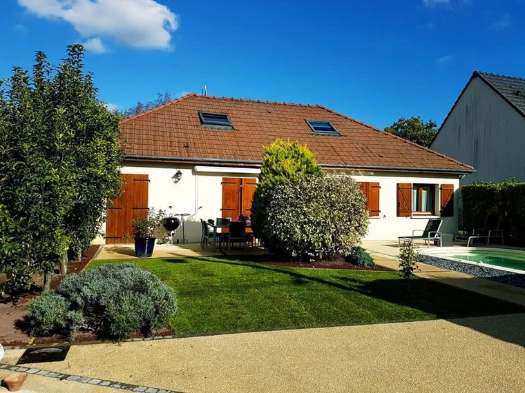 Jardin aménagé avec pelouse et piscine devant une maison